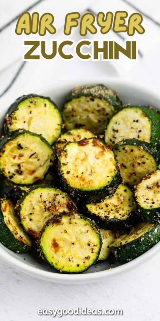 A bowl filled with sliced, seasoned, and air-fried zucchini, garnished with herbs. The text on the image reads Air Fryer Zucchini at the top and easygoodideas.com at the bottom.